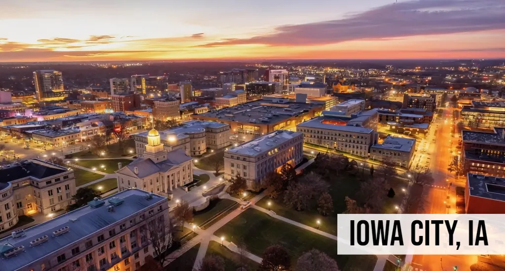 Land Buyers in Iowa – Iowa City, IA Iowa City, Iowa aerial view of downtown at night with illuminated streets and city grid