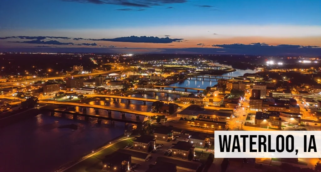 Quick Land Sale Iowa – Waterloo, IA Waterloo, Iowa aerial view of downtown at dusk with river, bridges, and surrounding city lights