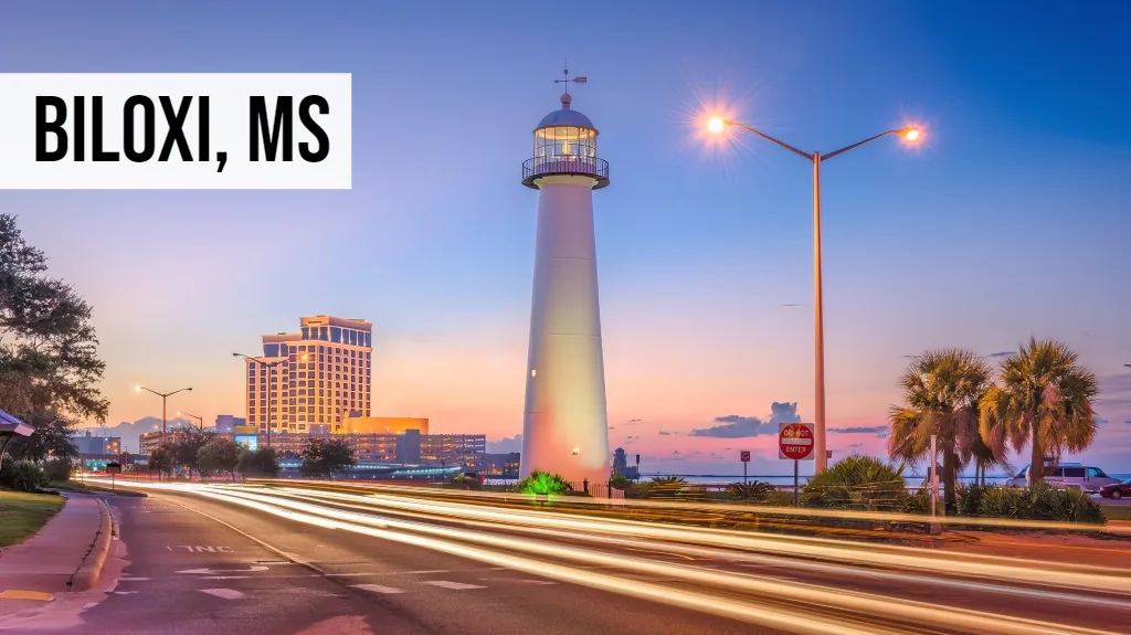 Biloxi, Mississippi waterfront city view with lighthouse, roadway, palm trees, and surrounding coastal area
