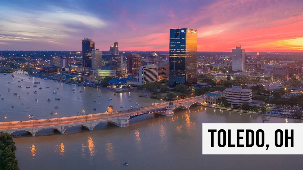 Sell Land Ohio – Toledo, OH Toledo, Ohio aerial view of downtown sunset riverfront with bridges, city buildings, roadways, and nearby residential areas
