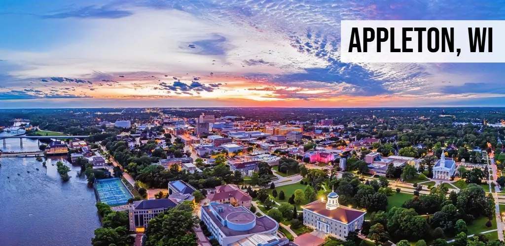 Appleton, Wisconsin evening aerial view of downtown with riverfront, buildings, streets, and surrounding city area