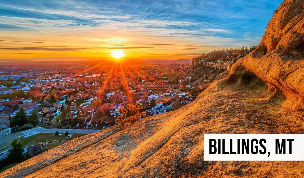 Billings, Montana aerial view at sunset with downtown buildings, rocky hills, and surrounding neighborhoods