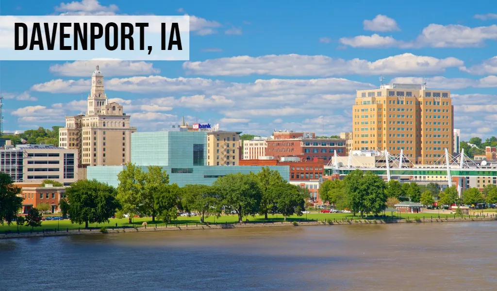 We Buy Land Iowa – Davenport, IA Davenport, Iowa skyline view along the Mississippi River with downtown buildings and riverfront
