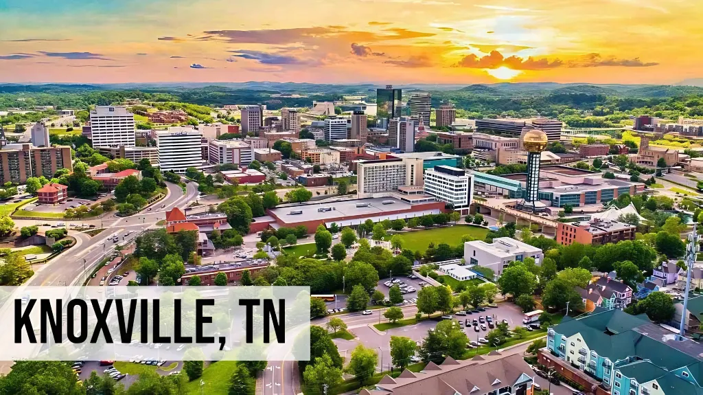 We Buy Land Tennessee – Knoxville, TN Knoxville, Tennessee elevated city view showing downtown buildings, nearby neighborhoods, tree-lined streets, and rolling hills in the distance