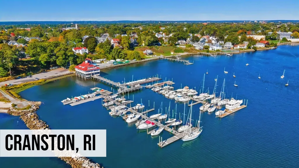 Cranston, Rhode Island aerial view of marina with boats, waterfront homes, trees, and surrounding neighborhood