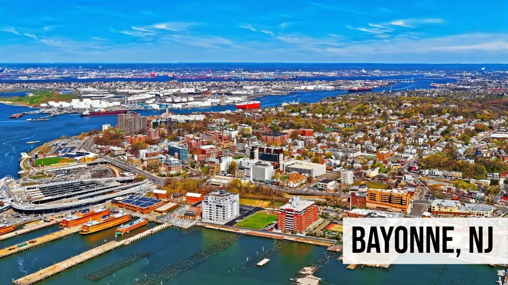 Bayonne, New Jersey aerial view of waterfront cityscape with buildings, shoreline, waterway, and surrounding urban area