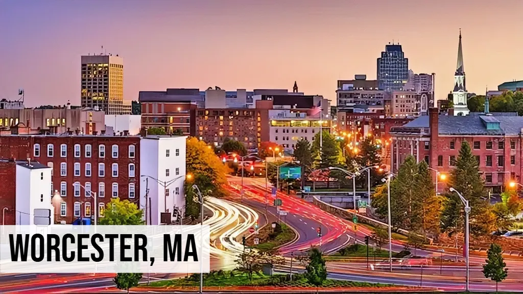 Worcester, Massachusetts downtown city view at dusk with historic buildings, roads, and surrounding urban area