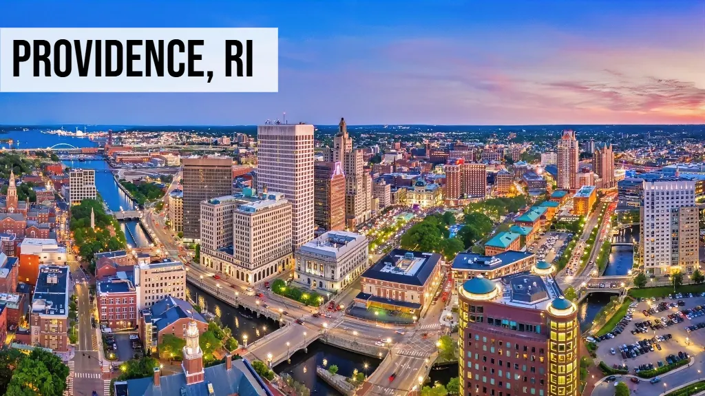Providence, Rhode Island downtown skyline at dusk with city buildings, roads, and surrounding urban area
