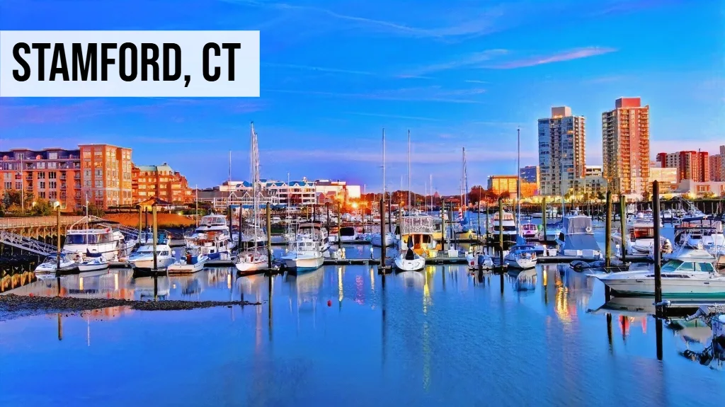 Stamford, Connecticut marina view with boats, waterfront buildings, docks, and surrounding city skyline