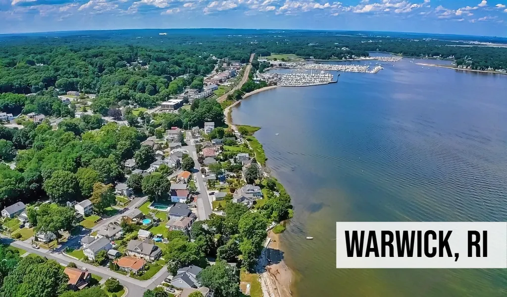 Warwick, Rhode Island aerial coastal view with shoreline homes, waterway, trees, and surrounding residential area